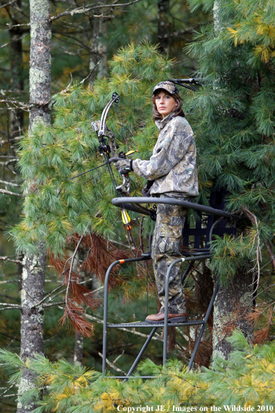Bowhunter standing in treestand. 