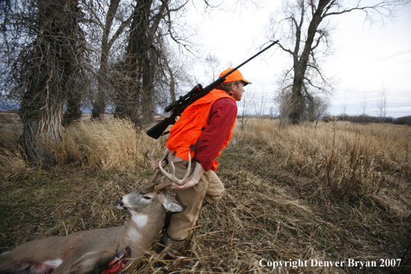 Hunter in field with bagged deer
