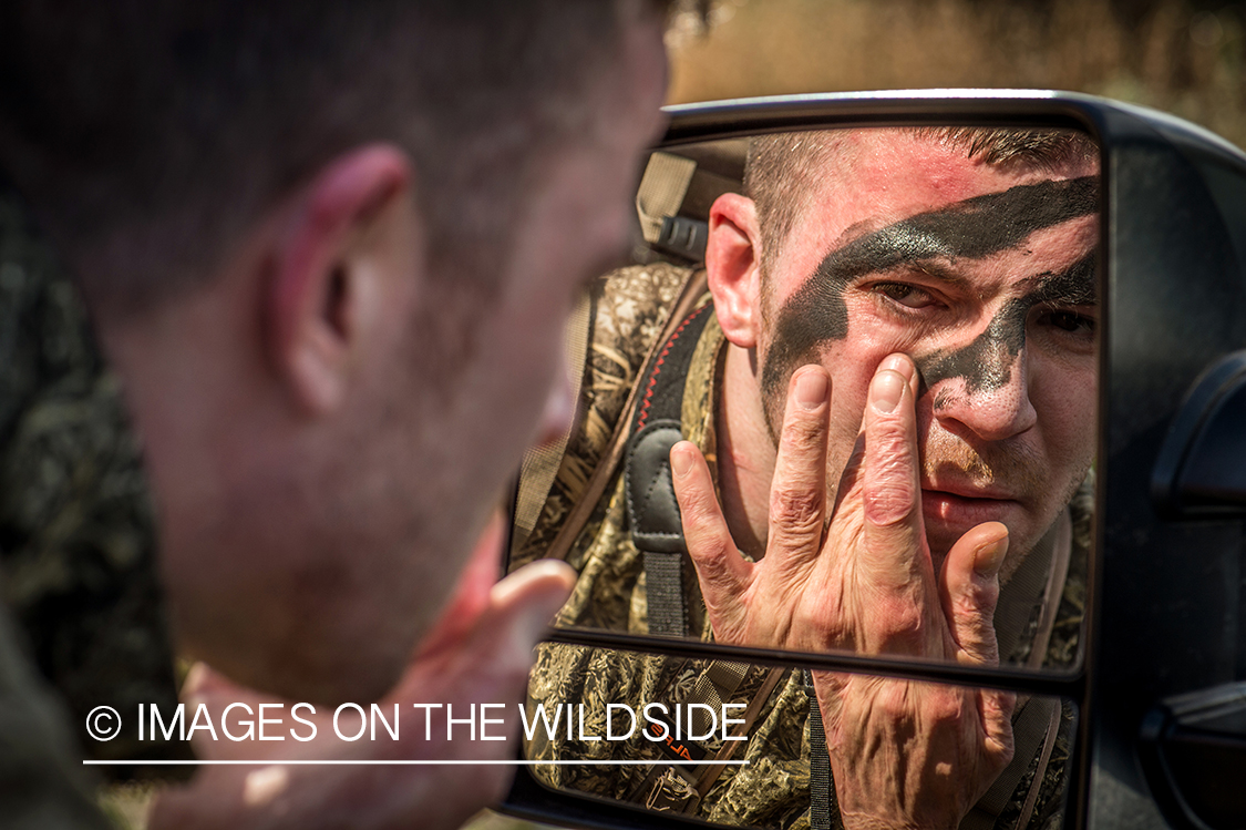 Hunter applying face paint.