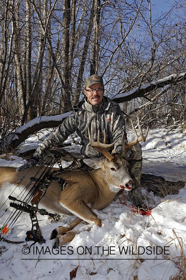Bowhunter with downed white-tailed buck.