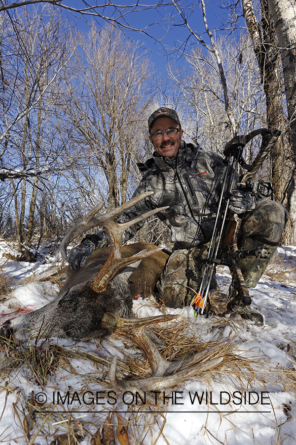 Bowhunter with downed white-tailed buck.