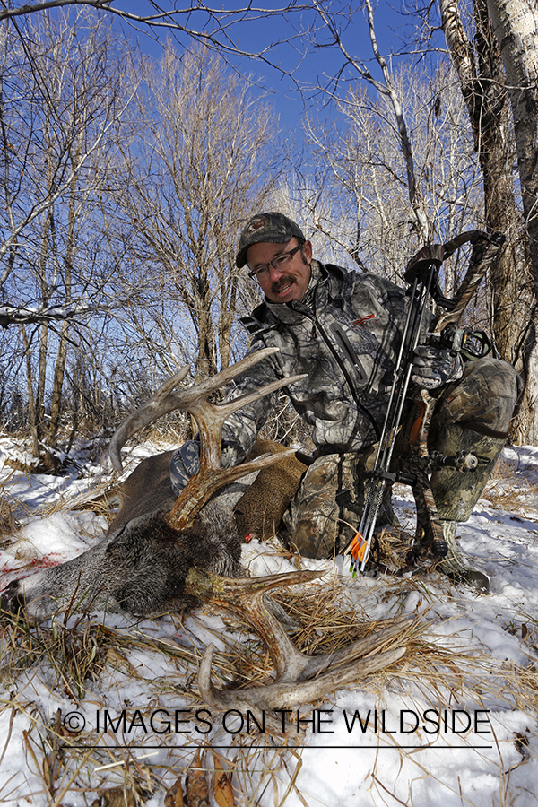 Bowhunter with downed white-tailed buck.