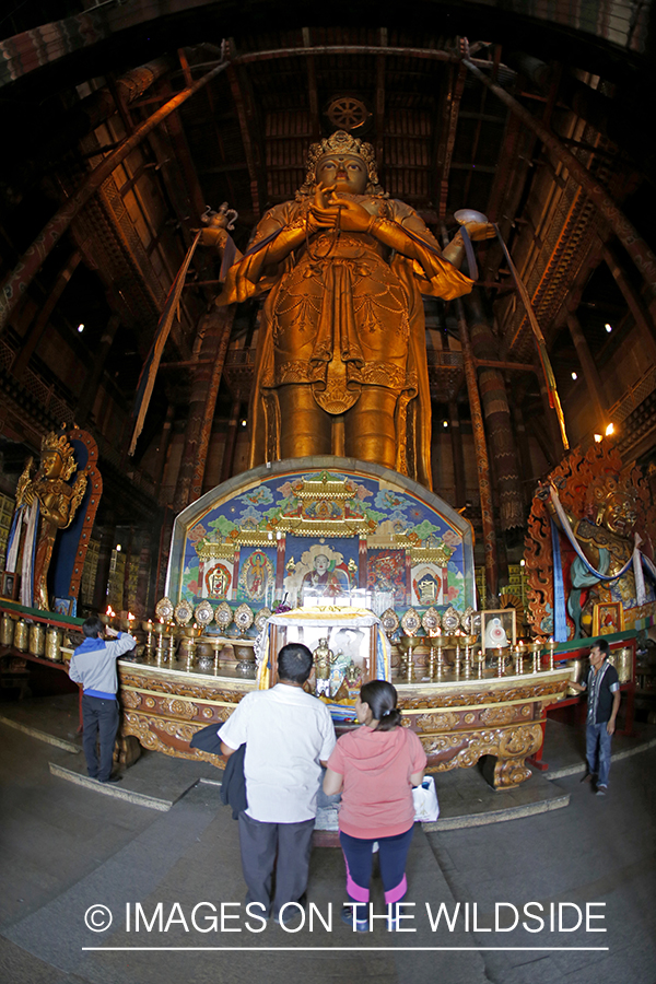 People in monastery at Buddhist statue, Ulaanbaatar, Mongolia. (97' tall)