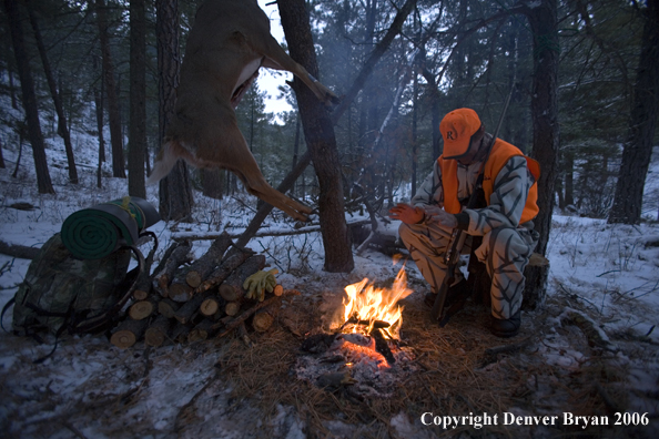 Deer hunter with bagged deer in camp in winter.  
