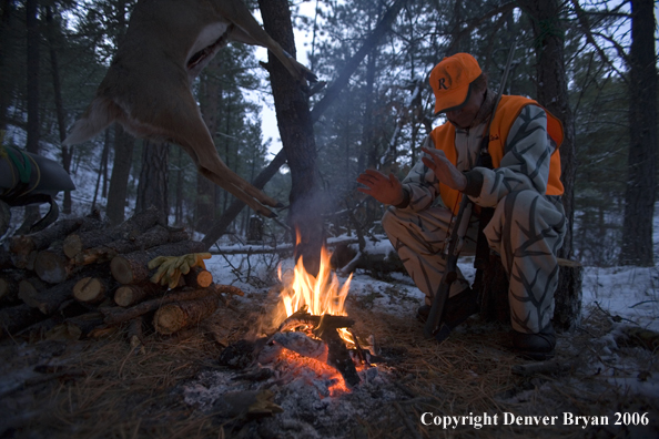 Deer hunter with bagged deer in camp in winter.  