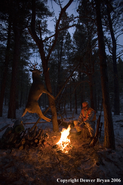 Deer hunter with bagged deer in camp in winter.  