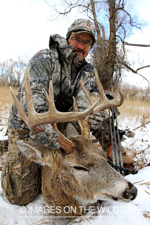 Bowhunter with bagged white-tailed buck.